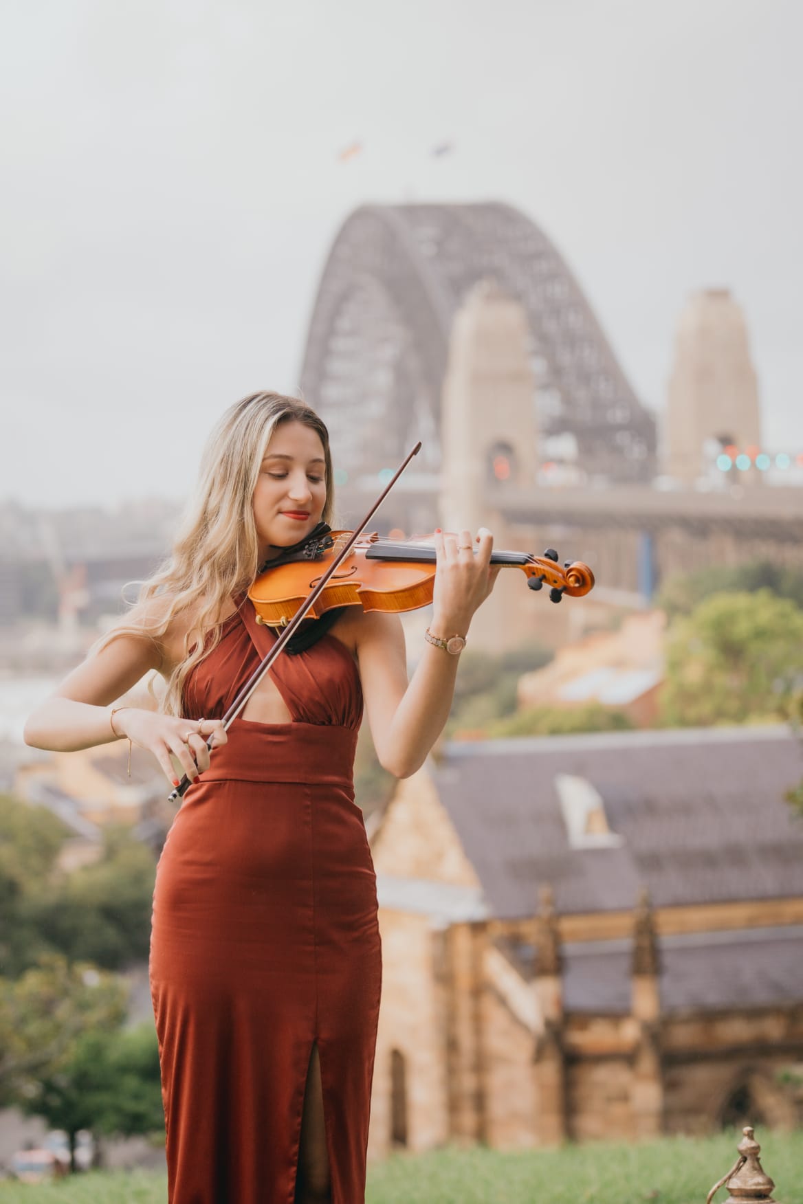 Tali playing violin in front of the Sydney Harbour Bridge